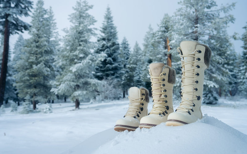Short, mid and tall Royal Canadian boots in Pale Ale White standing in fresh snow among pine trees