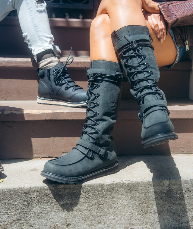 LAVAL tall lace-up boots and LUNA boots in black on city steps