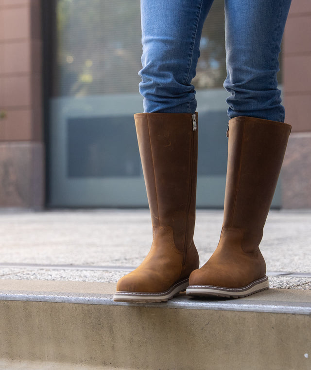 Brown LEXI tall boots on a city step