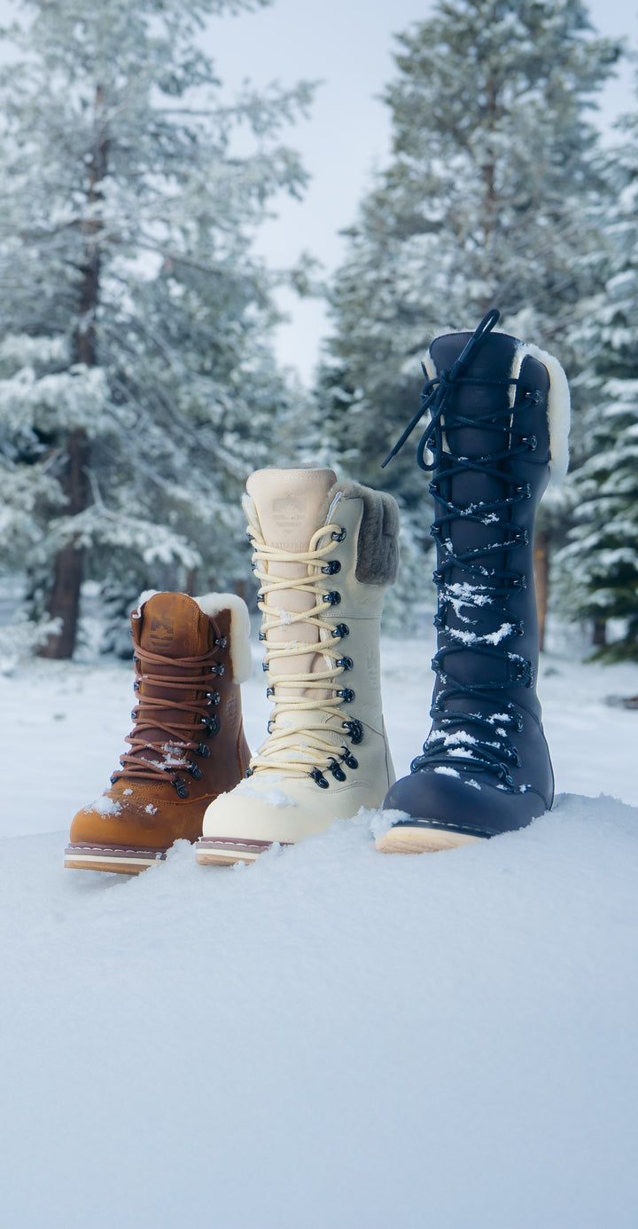 Three True North winter boots standing in fresh snow in a pine forest