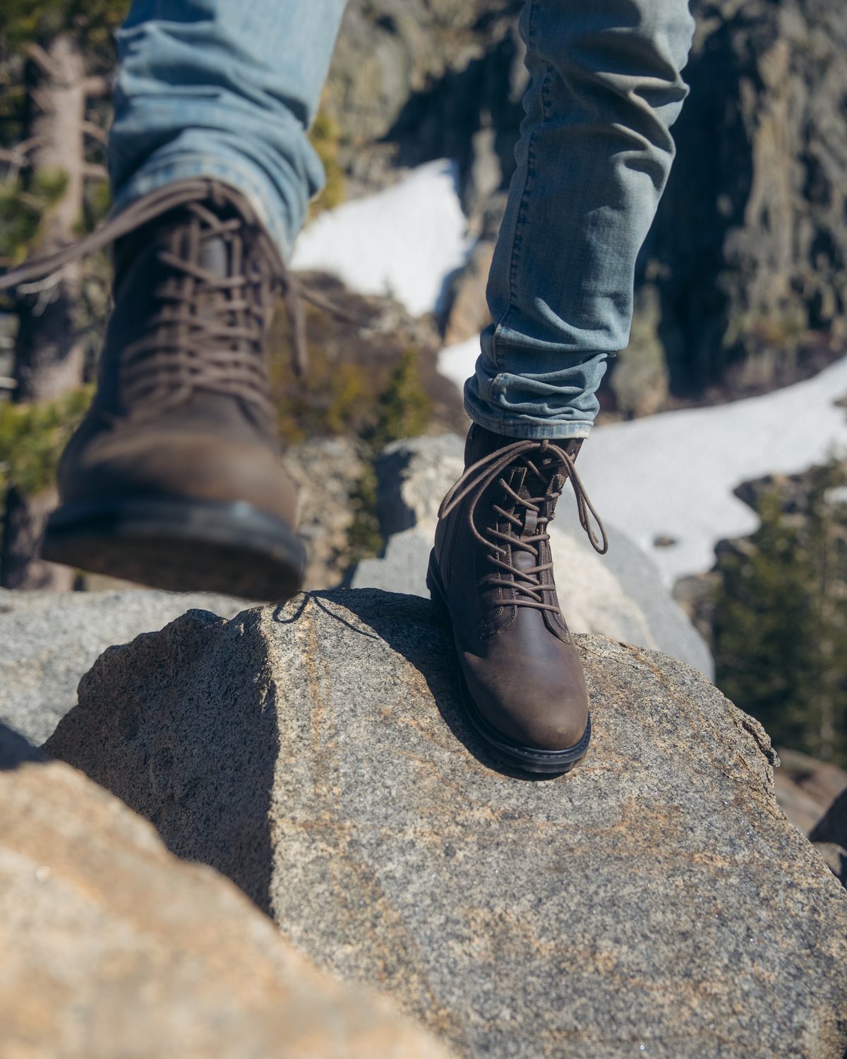 REGENT boots stepping across rocks and snow