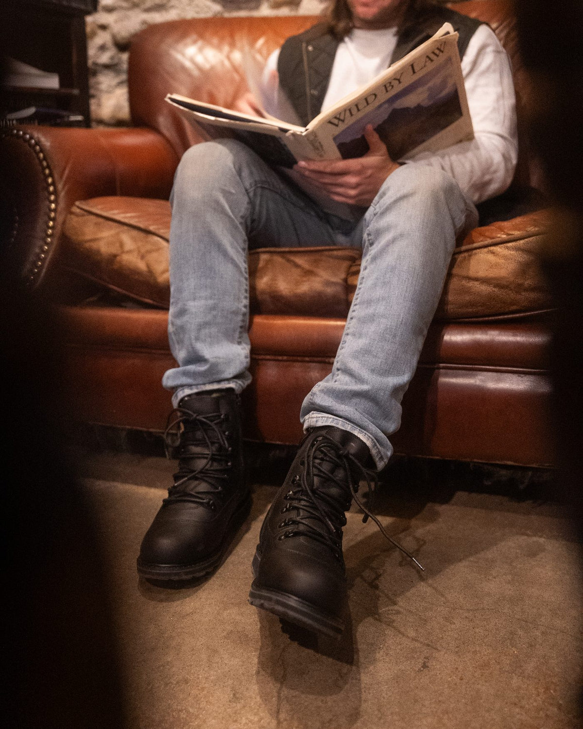 ARMSTRONG in Black, reading in a leather armchair
