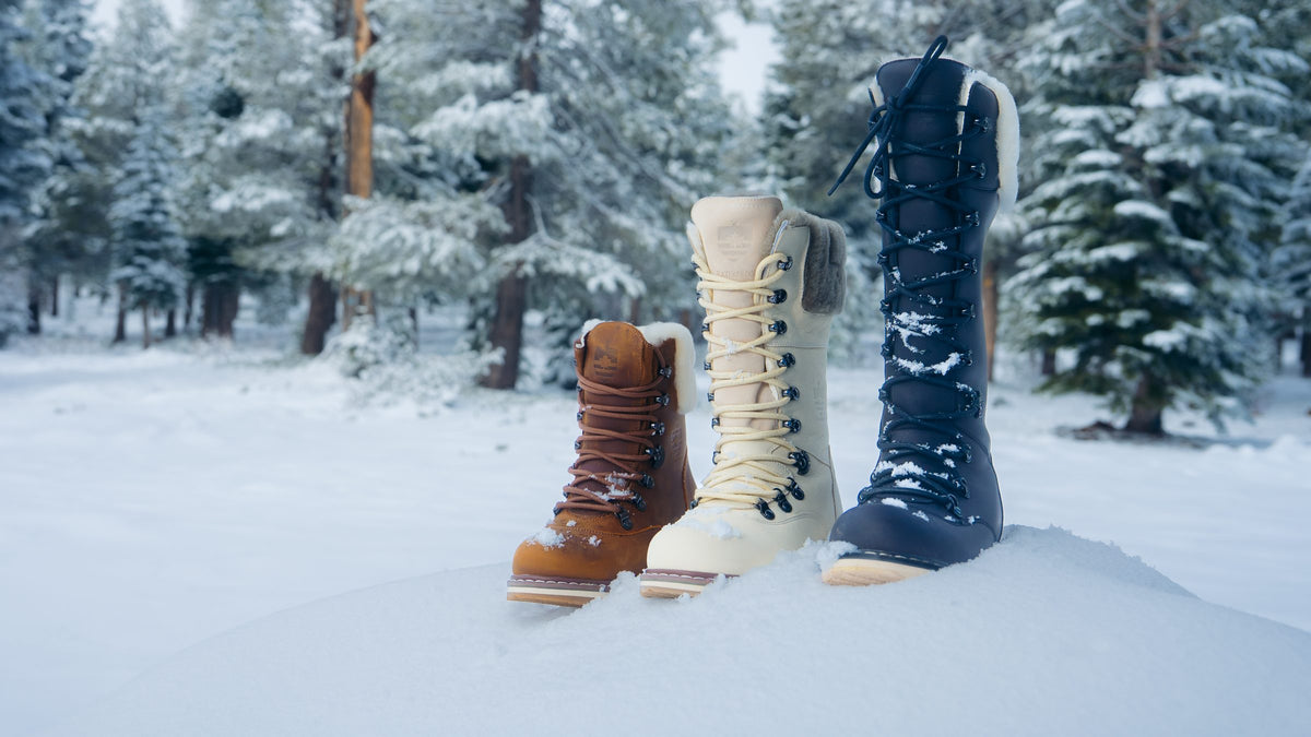 Three Royal Canadian boots standing in deep snow among pine trees
