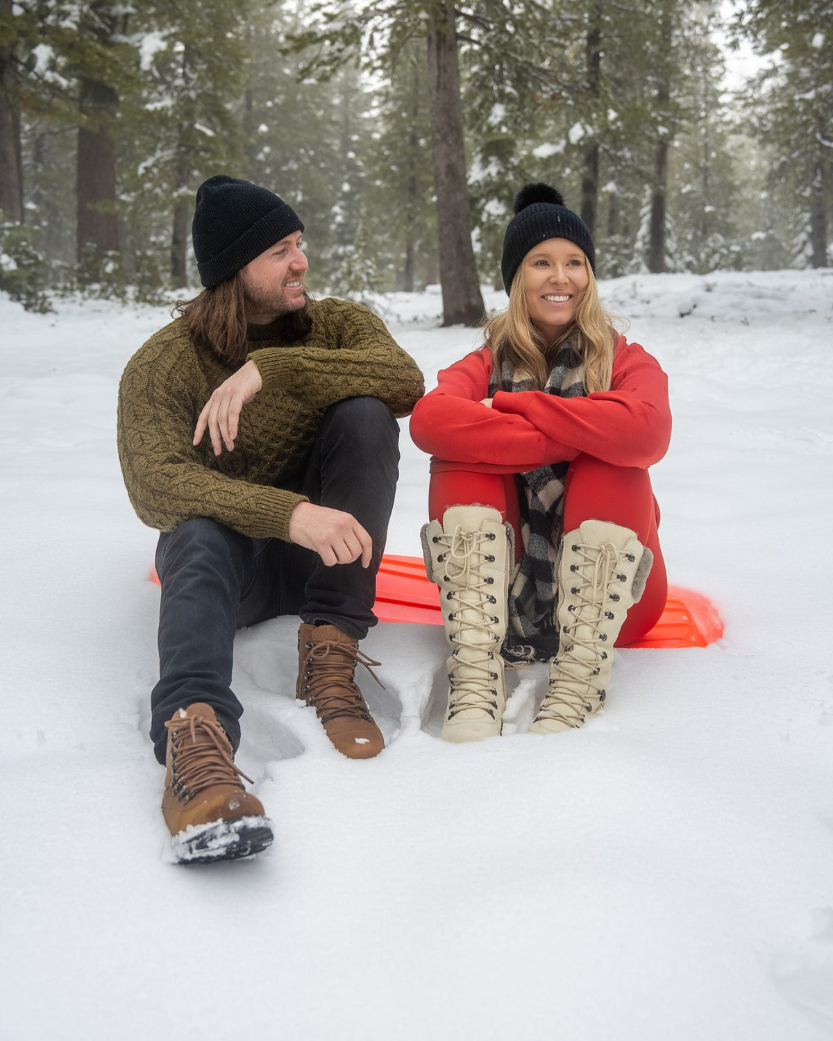 A couple resting by a sled in the snow, her in DALHOUSIE Pale Ale White
